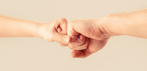 Little and big fists of father and son. Mother and kid daughter are fist bumping