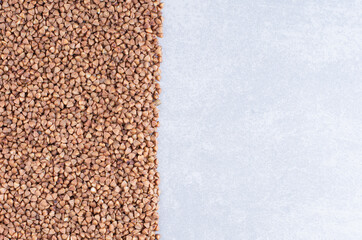 Buckwheat arranged into a rectangular pile on marble background