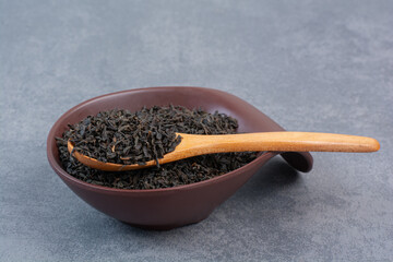 A dark plate full of infusion with wooden spoon