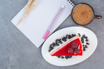 A sweet delicious piece of cake with sheet of paper on gray background