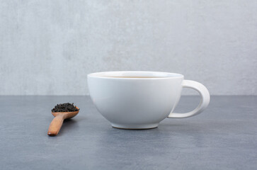 A cup of aroma tea with wooden spoon of infusion
