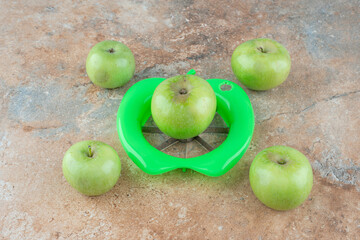 Green fresh apples with peeling tool on marble background