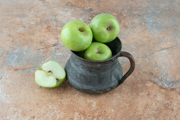 A fresh apples with an ancient cup on marble background