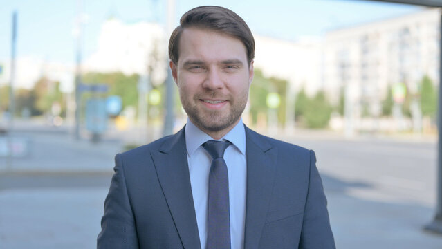 Portrait Of Agree Businessman Shaking Head In Approval Outdoor