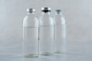 Three bottles of medical ethanol on gray background