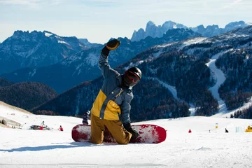 Foto op Plexiglas Snowboarder sitting on knees and waving at the camera © Percolated Photography/Wirestock Creators