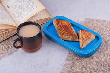 Plate of pastries with book and cup of coffee