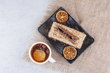 Plate of homemade cake with fruit tea on burlap