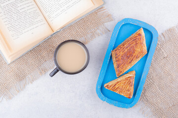 Plate of pastries with book and cup of coffee