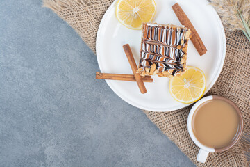 A white plate of creamy cake with cup of delicious coffee