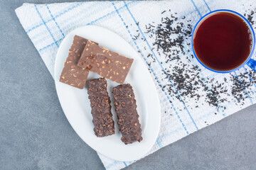 Sweet chocolates with cup of tea on tablecloth