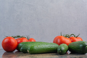 Bunch of tomatoes and cucumbers on marble background