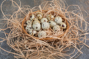 Obraz premium Bunch of quail eggs in wooden nest