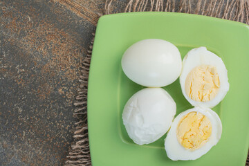 Tasty boiled eggs on green plate