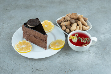 Slice of chocolate cake with tea and peanuts