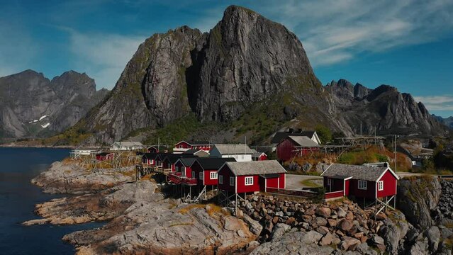 Aerial Moving traditional Norwegian fishermans cabins, rorbuer, on the island of Hamnoy, Reine, Lofoten islands, Summer of Norway.