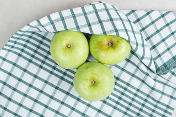 Whole green apples on striped tablecloth