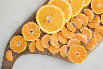 Orange and tangerine slices on wooden board