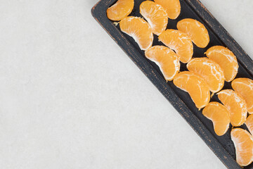 Juicy tangerine segments on black plate