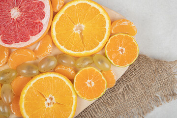 Bunch of citrus fruit slices on wooden board