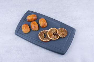 Homemade pastries with dried orange on dark plate