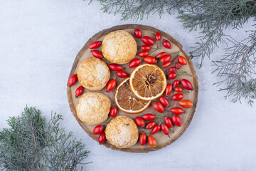 Obraz na płótnie Canvas Yummy cookies with orange slices and rosehips
