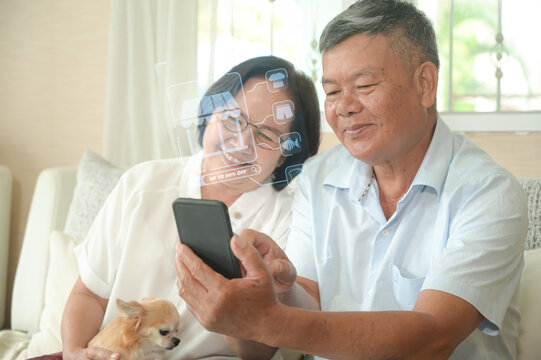 Retired couple searching for holographic merchandise discounts on smartphone, sitting on sofa with dog in living room, holographic photo.