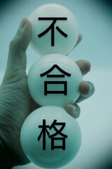 不合格と書かれたボールを持つ人物