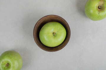 Tasty green apples in wooden bowl