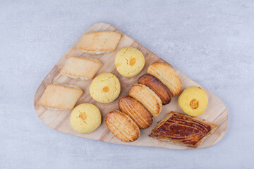Variety of tasty cookies on wooden board