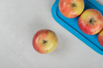 Whole red apples on blue plate