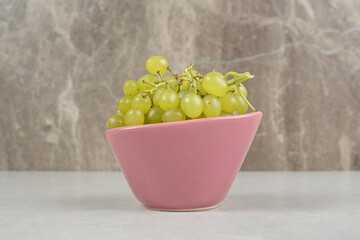 Fresh green grapes in pink bowl
