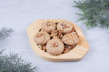 Cookies with walnut kernels on wooden plate