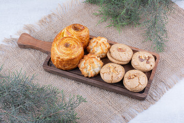 Variety of delicious cookies on wooden board