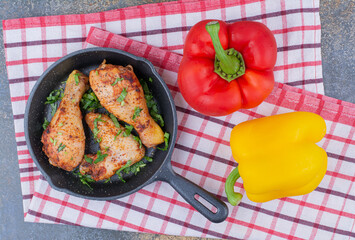 Grilled chicken drumsticks on pan with bell peppers