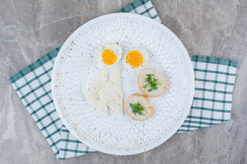 Tasty boiled eggs with spices and bread on tablecloth