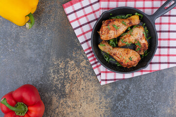 Grilled chicken drumsticks on pan with bell peppers