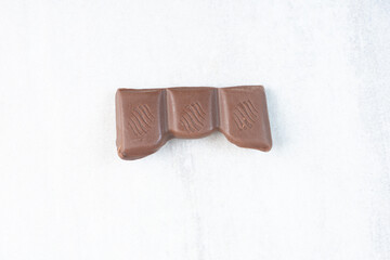 Piece of chocolate bar on stone background