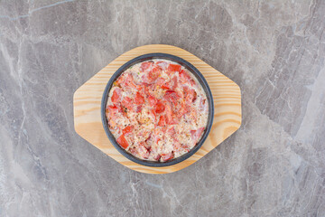 Tasty fried eggs with tomato on dark pan