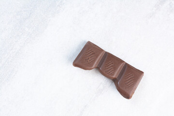 Piece of chocolate bar on gray background
