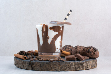 Glass of milk with straw, chocolate and cookies on wooden piece - Powered by Adobe