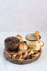 Crackers, bowl of coffee beans and cup of coffee on wooden piece