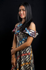smiling young Asian woman wearing batik clothes isolated on black background. Batik Day.