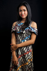 smiling young Asian woman wearing batik clothes isolated on black background. Batik Day.