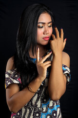 Beautiful young asian woman wearing batik isolated on black background. Batik Day.