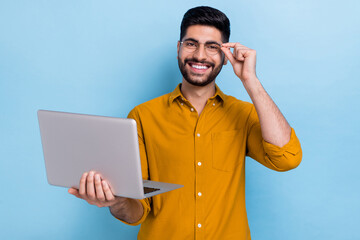 Photo of agent beard young guy hold laptop wear brown shirt eyewear isolated on blue color...
