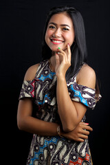 smiling young Asian woman wearing batik clothes isolated on black background. Batik Day.