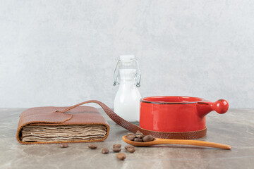 Coffee cup, beans and notebook on marble table
