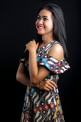 smiling young Asian woman wearing batik clothes isolated on black background. Batik Day.