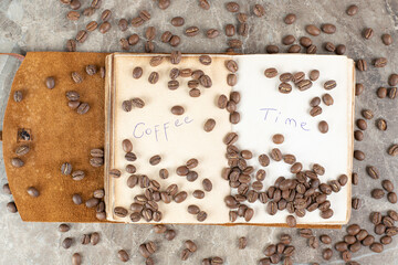 Bunch of coffee beans scattered on notebook